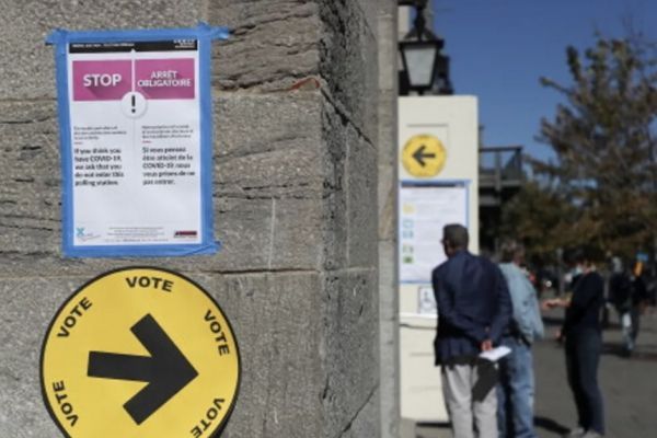 魁省市政选举投票时需要摘下口罩